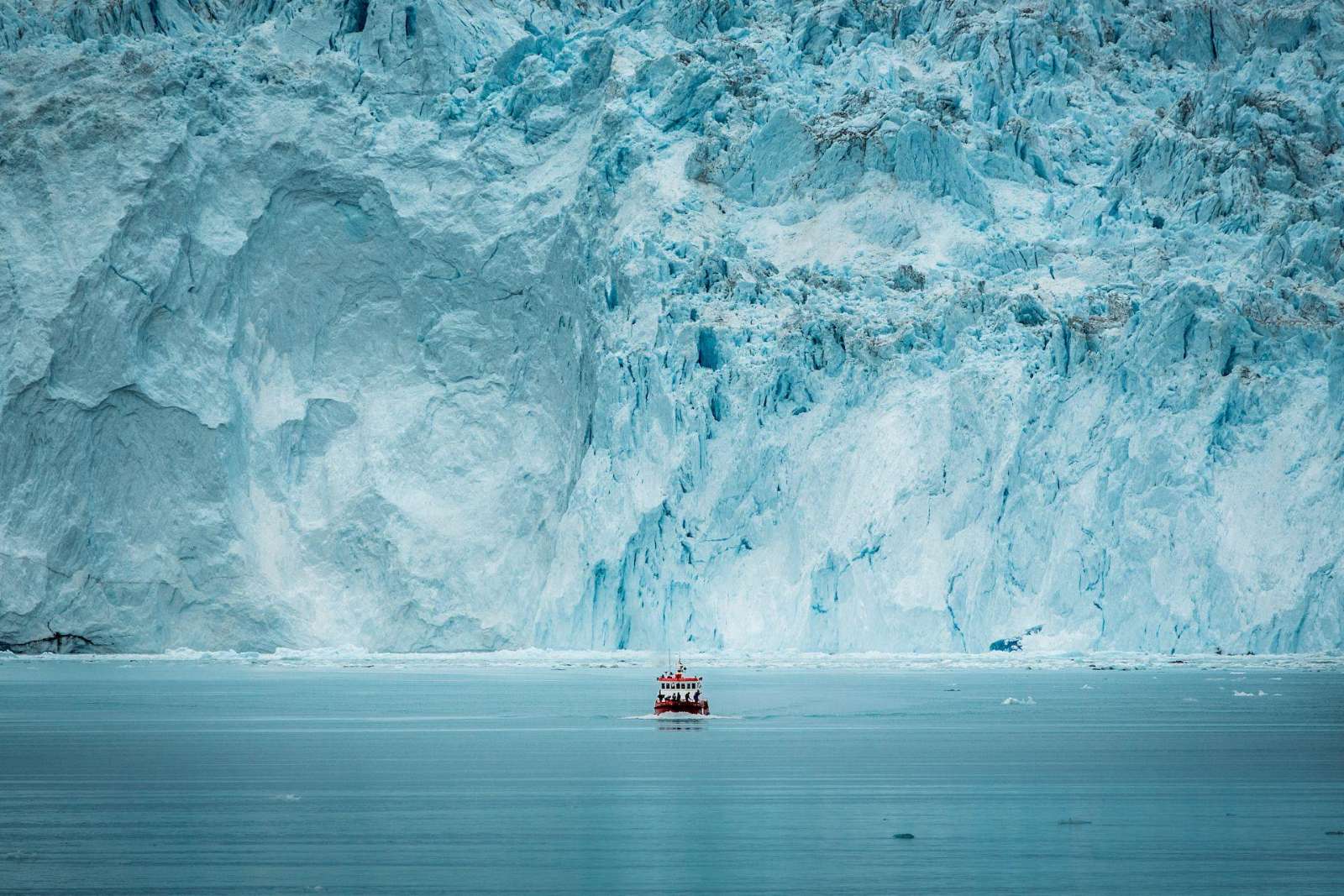 A boat before the glacier wall at Eqi, Greenland